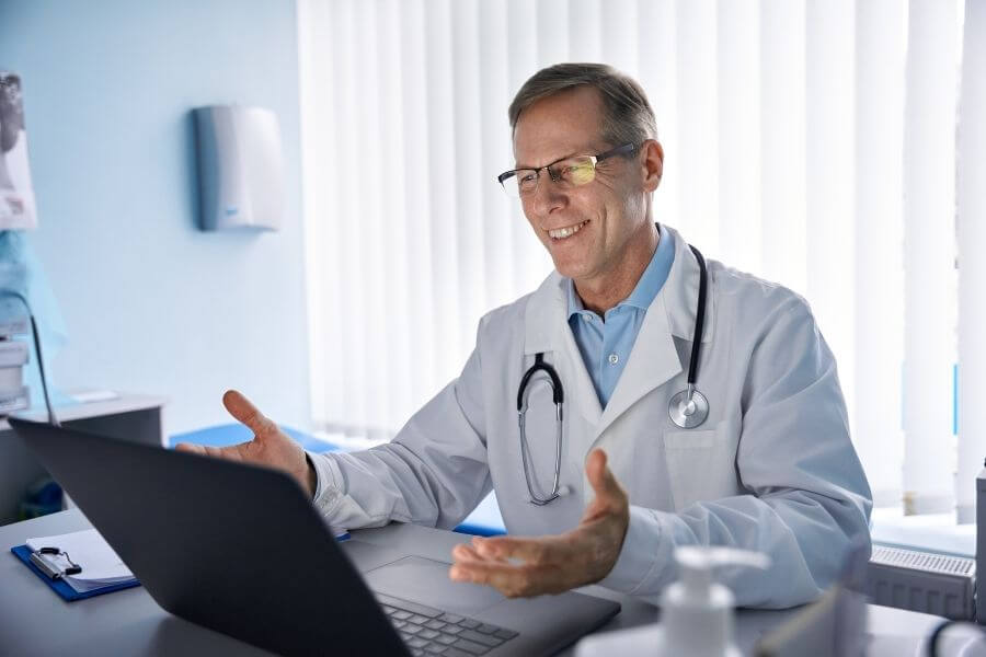 Happy physician on a laptop
