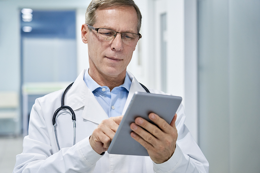 Doctor using a tablet, dashboard, database